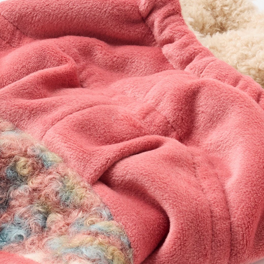 身頃の表はくるくるの素材感がかわいいファー素材、裏面は起毛した厚みのあるしっかりとした素材です。フードは表地が手触りの良い少し光沢のあるフリース素材で、裏地は毛足の短いファー素材です。